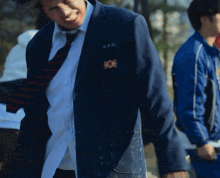 a man in a suit and tie has a badge on his jacket that says ' x '
