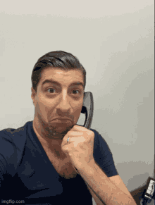 a man with a ring on his finger is making a funny face while talking on a phone