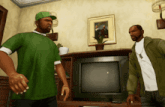 two men are standing in front of a television in a living room