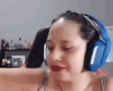 a woman wearing a pair of blue headphones is sitting in a chair .