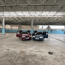 a group of people standing next to two cars one of which has a license plate that starts with the letter t