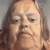 a close up of a woman 's face with a very serious look on her face .