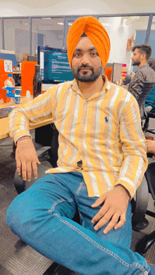 a man in a turban sits in front of a computer