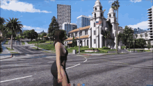 a woman in a black dress walks down a street in front of a building with an american flag on it