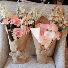 two bouquets of flowers and mary kay products are on a chair