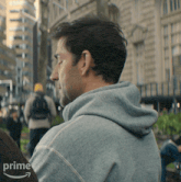 a man wearing a grey sweatshirt with the word prime on the bottom right