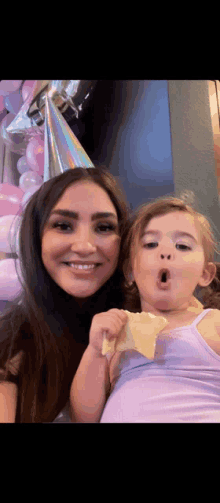 a woman and a little girl are posing for a picture