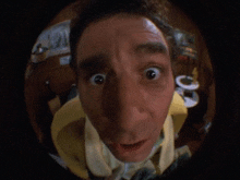 a close up of a man 's face looking through a fisheye lens