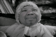 a black and white photo of a baby in a crib