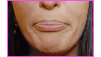 a close up of a woman 's face with her mouth open and her tongue sticking out .