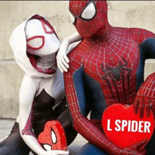 a man in a spiderman costume holds a red heart that says l spider on it