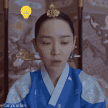 a woman in a blue and white kimono has a light bulb above her head