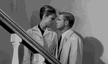 a man and woman are standing next to each other on a set of stairs .