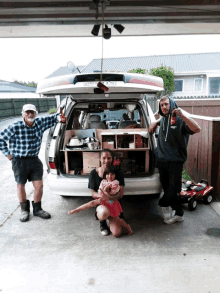 a group of people standing in front of a van that says ' toyota ' on the back