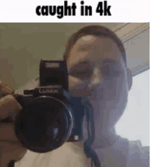 a man is taking a picture of himself with a camera in a 4k video .