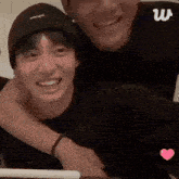 two men are hugging each other and smiling at the camera .