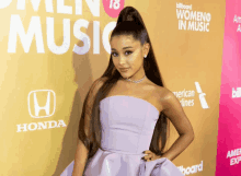 a woman in a strapless purple dress stands in front of a billboard that says women in music