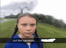 a girl with pigtails is standing in front of a factory with smoke coming out of it