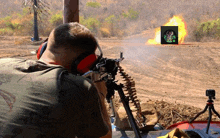 a man shooting a gun with a target in the background that says " fire "