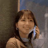 a woman is smiling and talking on a cell phone