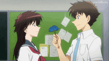 a boy is giving a blue flower to a girl in front of a green board that says javi-fullbuster