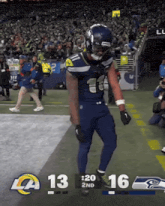 a football player stands on the field with a score of 13 to 16