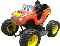 a boy sits in a red monster truck with the number 27 on the side