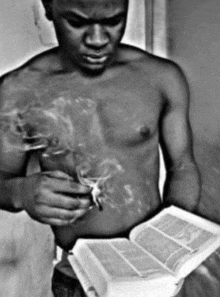 a man smoking a cigarette while reading a book