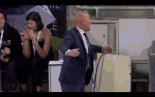 a man in a suit and tie is dancing in front of a woman in a black dress