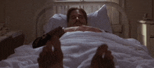 a man is laying in a hospital bed with his feet outstretched