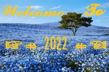 a field of blue flowers with a tree in the background and the words welcome to 2022