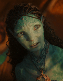 a close up of a woman 's face with green paint on it