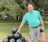 a man wearing a t-shirt that says ' florida ' on it stands next to a pile of black balls