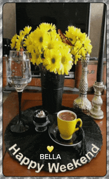 a picture of a vase of yellow flowers and a cup of coffee says bella weekend