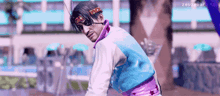 a man wearing a headband and sunglasses is standing in front of a pool in a video game .