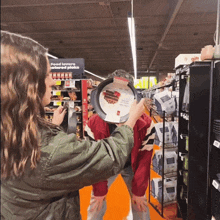 a woman holds a pan over a man 's face in a store with a sign that says food lovers and pizza