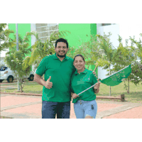 a man and a woman are posing for a picture and the man is wearing a green shirt that says ' alianza '