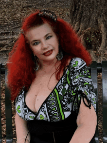 a woman with red hair is sitting on a park bench wearing a green and white top