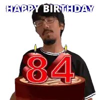 a man with glasses is holding a cake with candles in the shape of the number 84