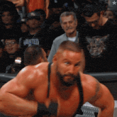 a man in a black shirt that says wanted is standing in front of a crowd