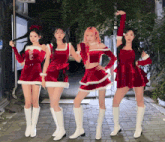 a group of four women dressed in santa outfits are posing for a picture