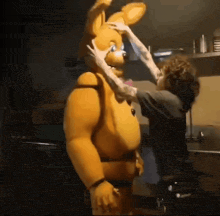 a man is touching the face of a stuffed animal