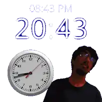 a man stands in front of a clock that says 20:43
