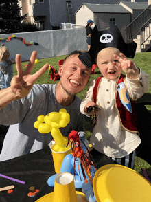 a young boy in a pirate costume giving a peace sign