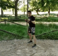 a man wearing shorts with a star of david on them is standing on a dirt path in a park