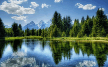 mountains are reflected in a lake surrounded by trees