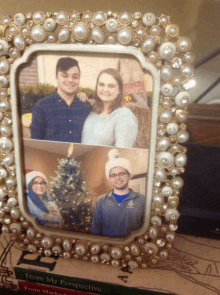 a picture frame with pearls and rhinestones holds a picture of a man and woman