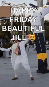 a man in a white suit is dancing in front of an inflatable batman balloon .