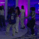 a group of people are dancing in front of a sign that says ment