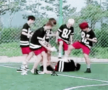 a group of young men are playing soccer on a field and one of them is laying on the ground .